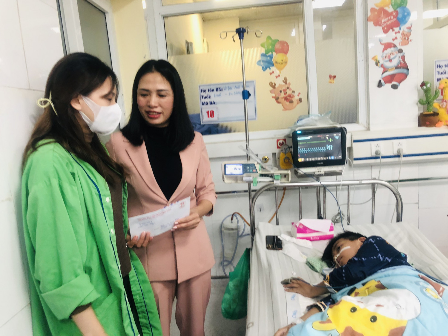 Đại diện Ban giám hiệu, Hội CMHS trường Tiểu học Trần Đăng Ninh tặng quà cho em Vũ Đức Anh Khoa hoc sinh lớp 3A3